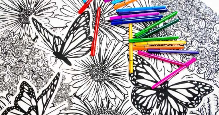 adult coloring books page with colored pencils on top